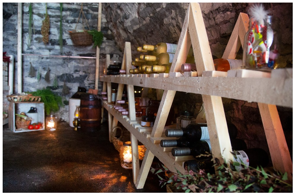 Root cellar stocked with wine bottles and lanterns