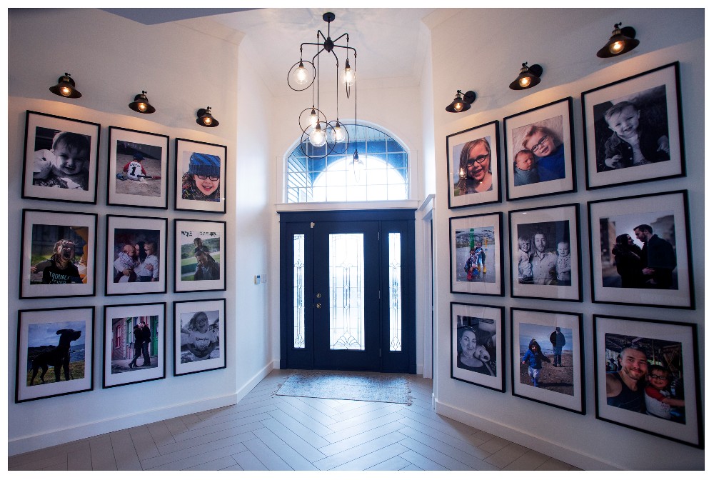 A foyer with family pictures as a large gallery wall