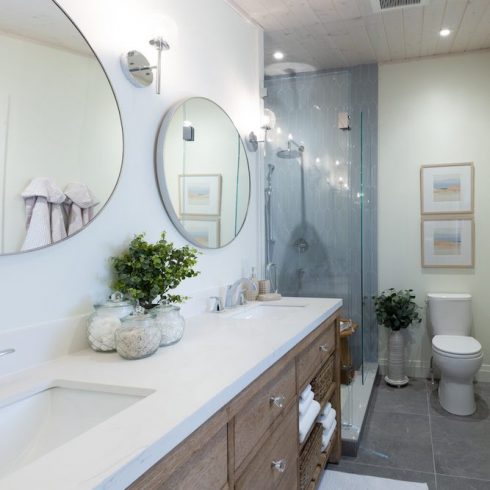 Renovated all white ensuite with dark wood dual vanity and glass shower