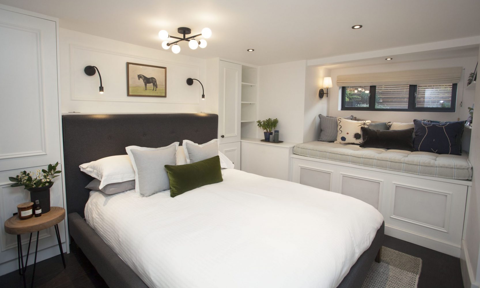 Custom closets and a window bench in a pretty basement bedroom