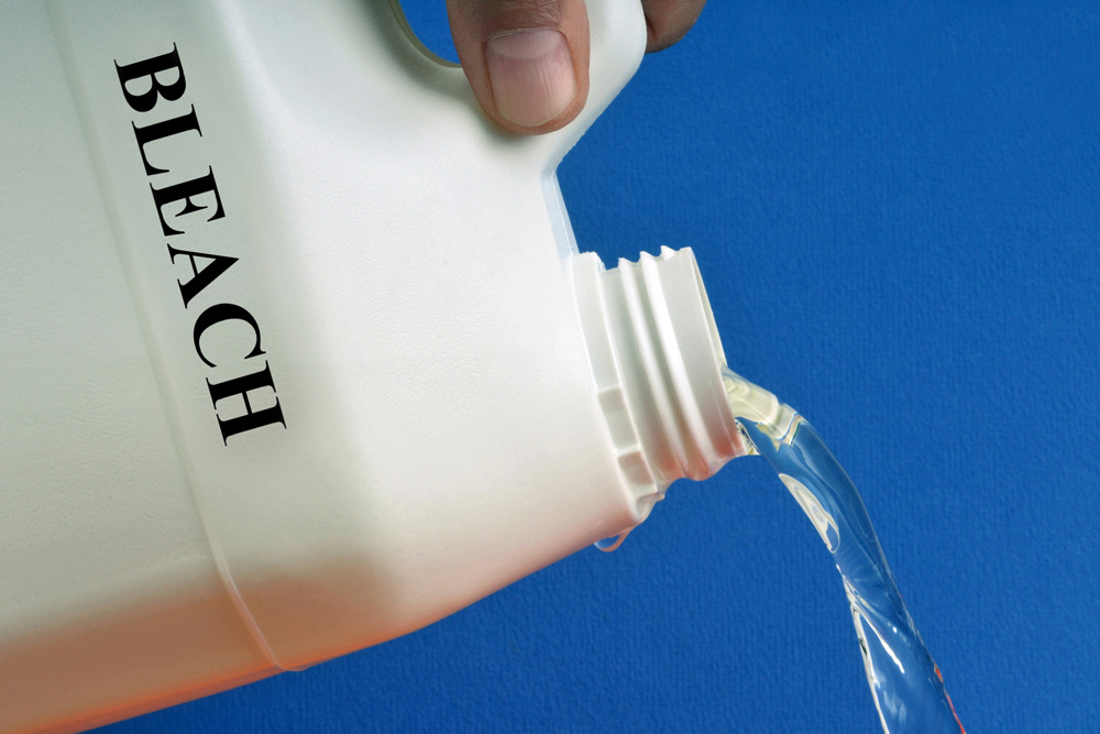 Person pouring bleach from a bottle