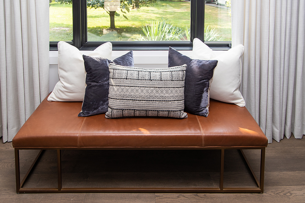 leather chair with pillows in front of window