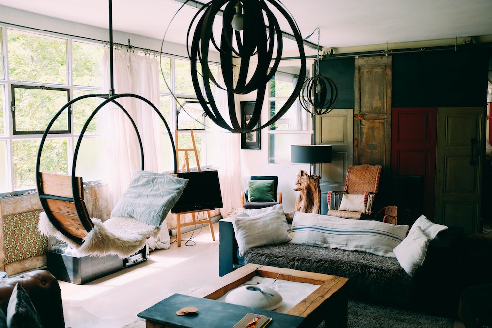 hanging chair and couch topped with comfy blankets and textiles