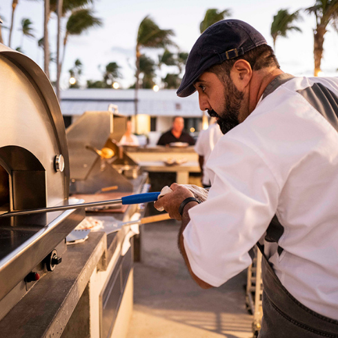 Man preparing pizza outside of Caerula Mar Club