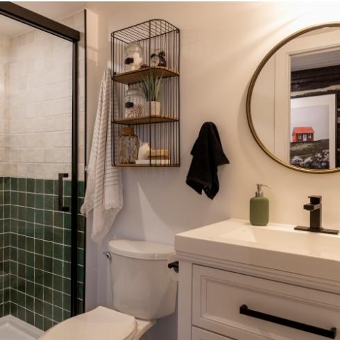 Renovated vacation house bathroom with a circular mirror over the vanity