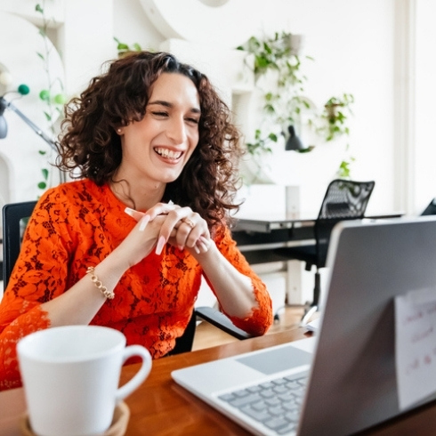 Woman wearing a red dress on a laptop