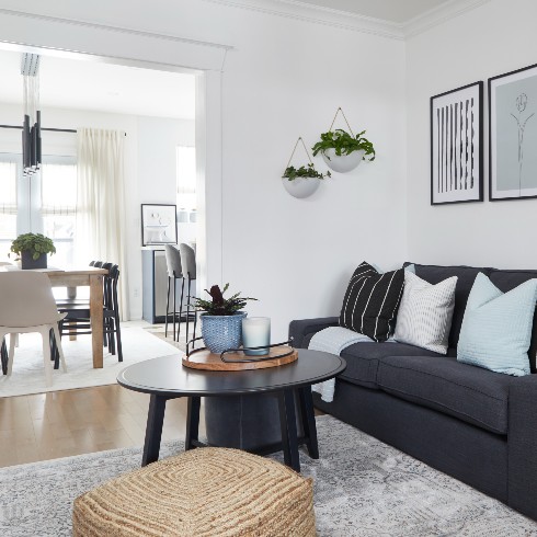 Modern living room with graphic prints and woven ottoman