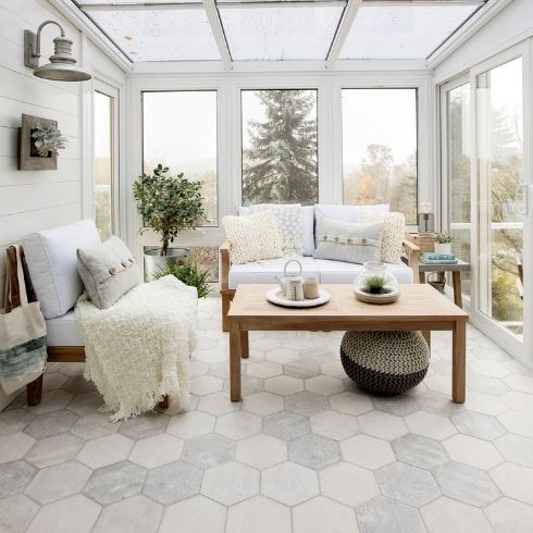 Covered patio with white wooden furniture and a throw blanket