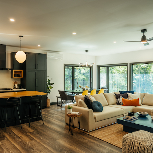 Living room kitchen with white couches and brown cabinets