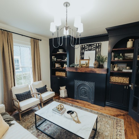 Living room with antique fireplace cover and custom built ins