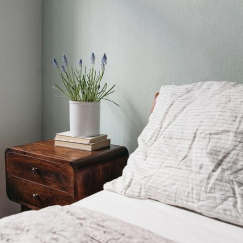 light green bedroom with wooden bed and night stand