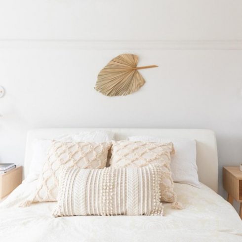 White bedroom with white bedsheets and gold leaf