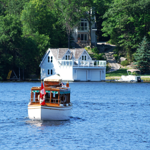 old wooden boat heading to cottage boathouse