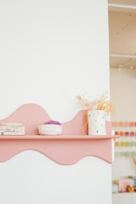 Pieces of white decor on a wavy shelf