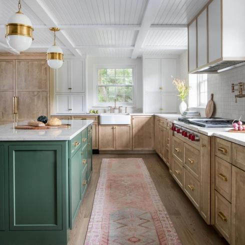 Kitchen with green island and light wood cabinetry