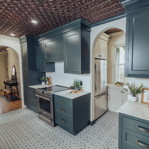 Kitchen with teal blue cabinetry and tiled floor