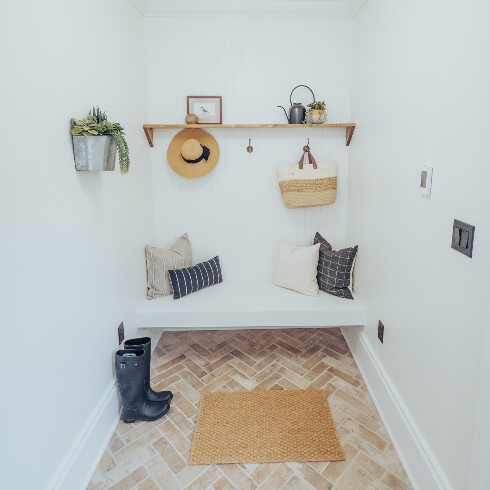 A mudroom with herringbone brick floor