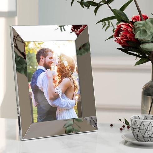 A silver digital frame with a wedding photo of a couple.