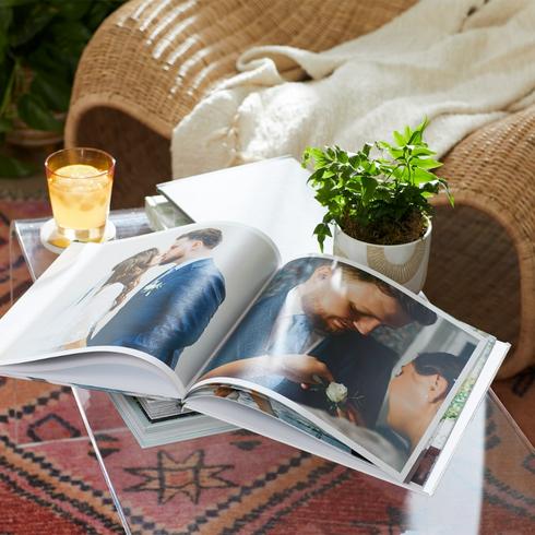 A wedding photo book displayed on a coffee table in a living room.