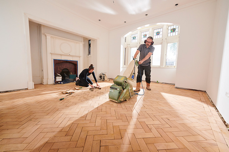 person sanding a floor