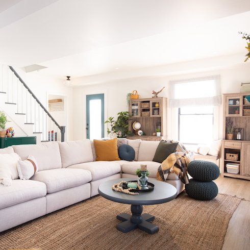 Open concept living room with a bright sectional and a dark round coffee table