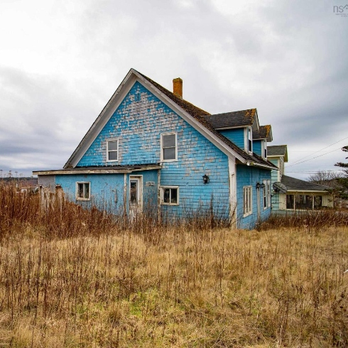 A two-storey century home with weathered light blue siding