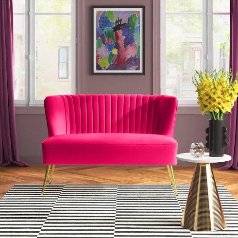 A hot pink two-seater loveseat in a neutral grey living room