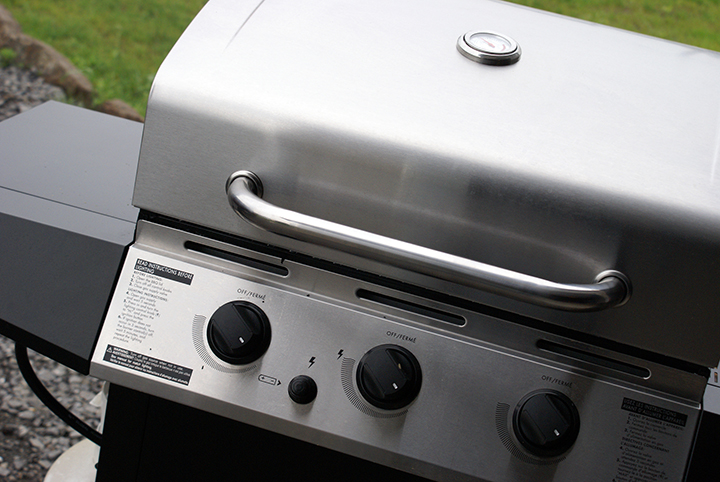 A closed silver grill with black buttons. 