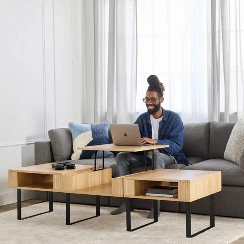 Man sitting on couch with laptop and a lift top coffee table