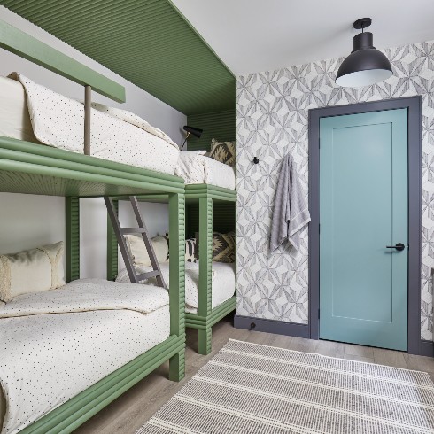 Bunk room with green beds and a blue door