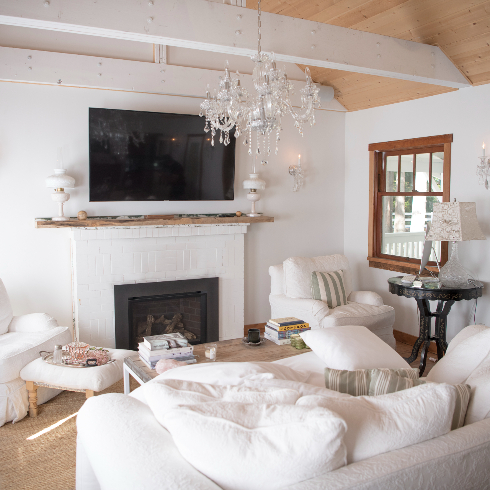 White-covered couches and chair in a television area of the front room at The Roadhouse