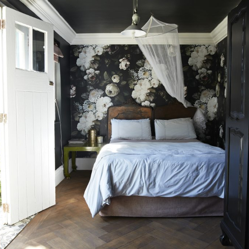 A beautiful dark floral print wallpaper in a room with black and white accents