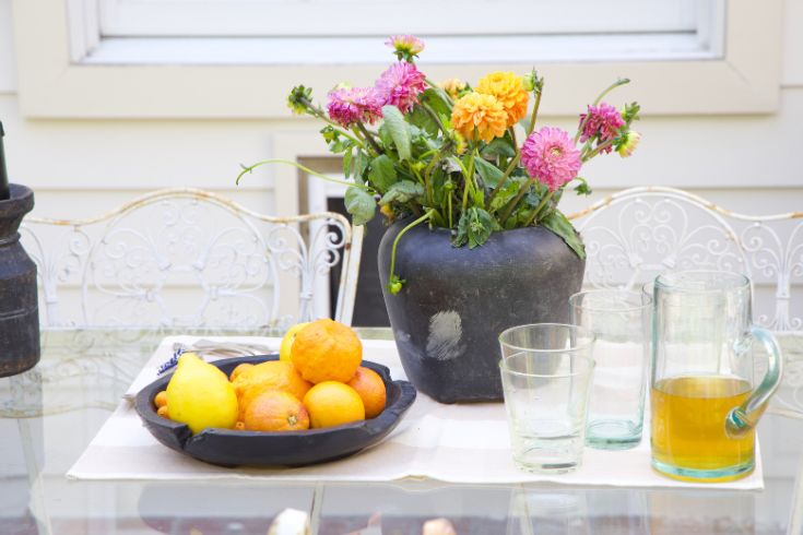 Table with vase of flowers and lemon in bowl