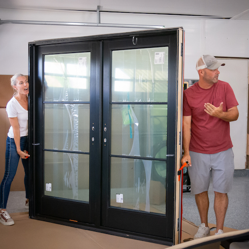 Bryan and Sarah Baeumler carrying doors