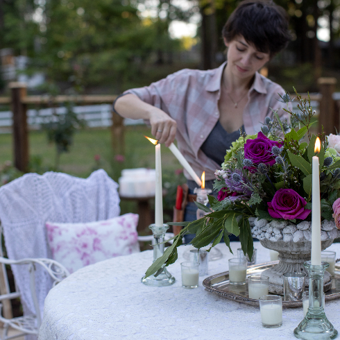 Francesca lights candles on the table located in the pavillion