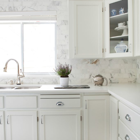 A classic and clean-looking white kitchen with a tile backsplash