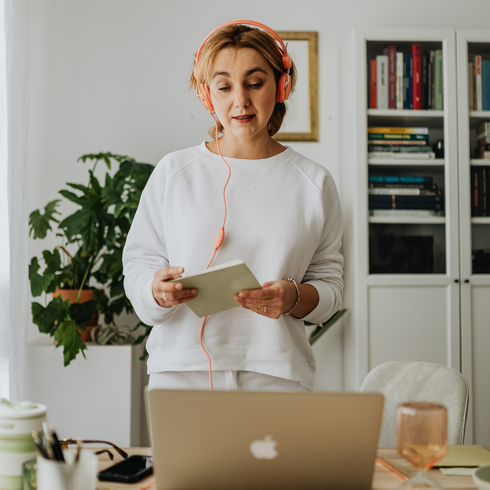 woman standing on desk at home holding a tablet