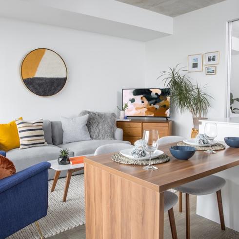 Condo with countertop, blue arm chair and grey couch.