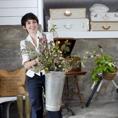 Designer Francesca holds up a vintage bucket with flowers