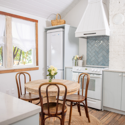 A shot of The Cabin kitchen, with small European fridge, new range and blue tile backsplash