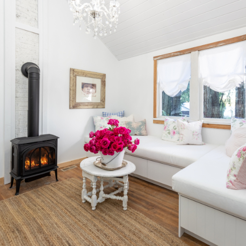 The living room space in The Cabin with cozy wood-burning oven and L-shaped couch