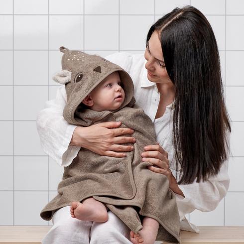 A kid snuggled up in a deer towel