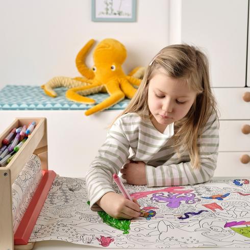 A kid colouring with crayons