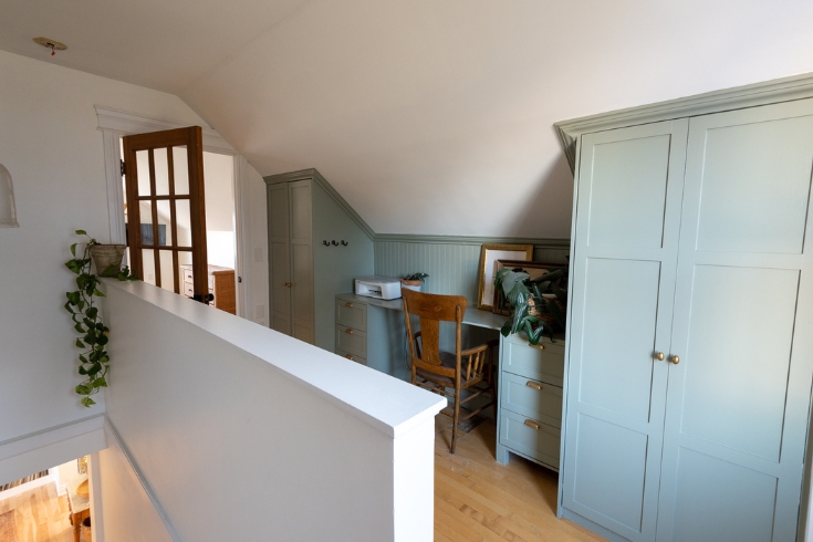 An office alcove on an upstairs landing with built-in closets on either side