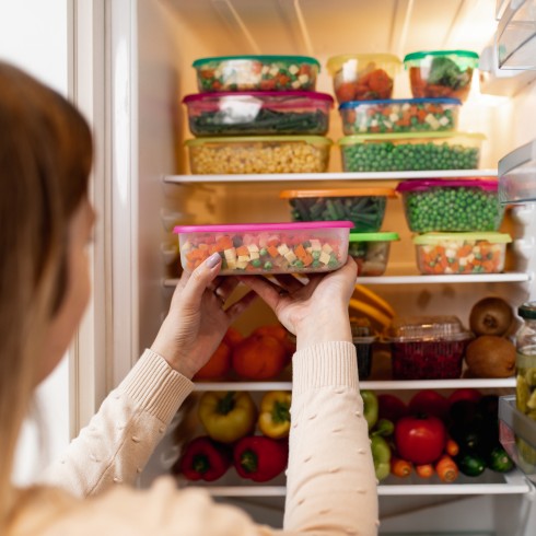 person putting things in a fridge