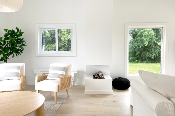 Prince Edward County's The Canada House: living room with firepit and windows. 