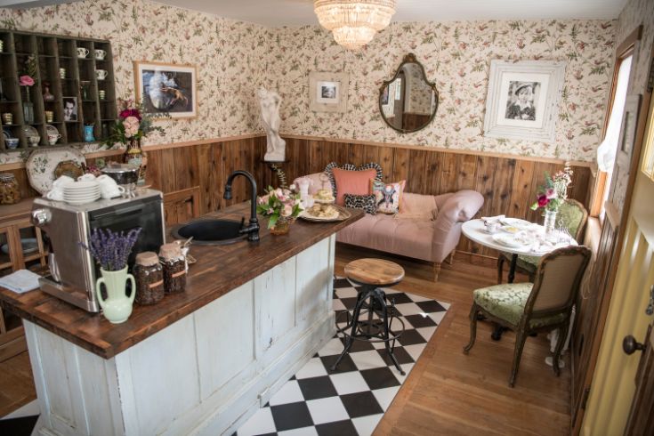 Front room with floral wallpaper and coffee station over a dark wood counter
