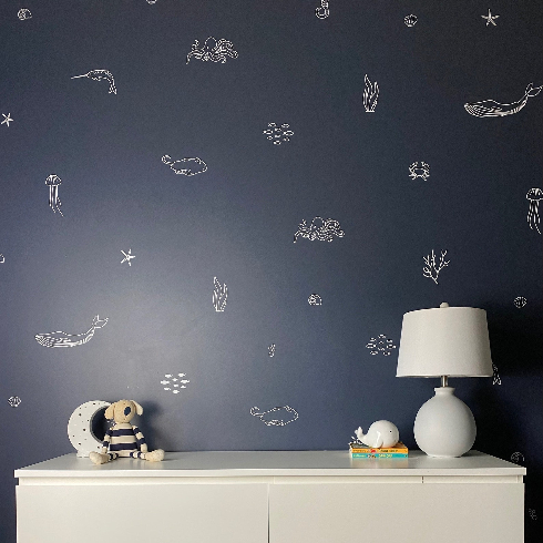 A dark blue painted wall with white sea creature wall decals