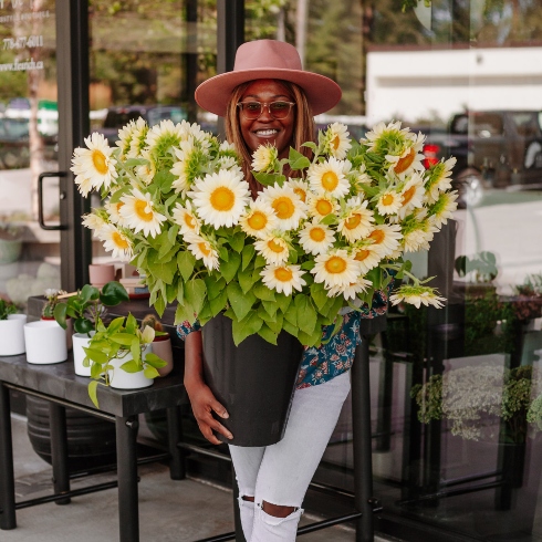 Laurence Rich of FleuRich Creations holding a large sunflower arrangement