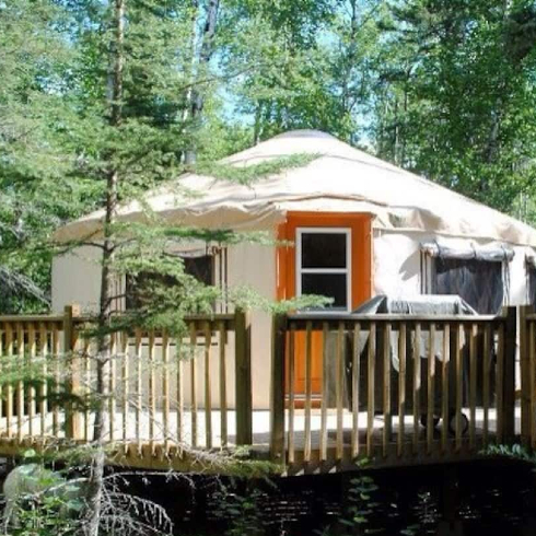 The exterior of a cozy forest yurt